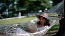 Relaxing Woman Reading Book in Hammock in Sunny Garden