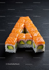 Sushi rolls shaped into letter A on dark slate