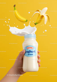 Hand Holding Banana Yogurt Drink with Splash on Yellow