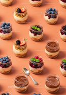 Assorted layered desserts with fresh berries in glass jars