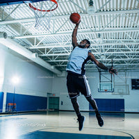Athlete Jumping to Score a Basketball Dunk