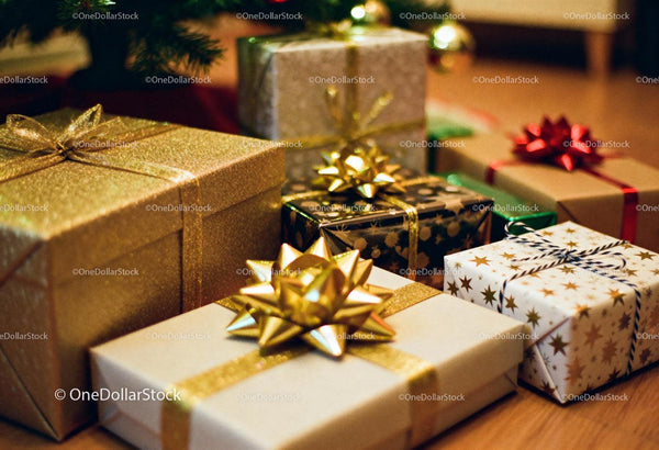 Assortment of festive wrapped Christmas gifts under tree
