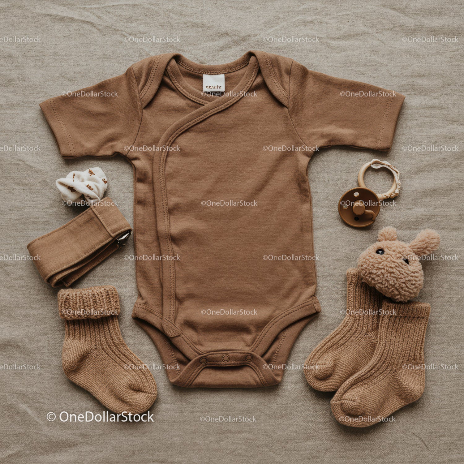 Neutral brown baby clothing and accessories flat lay