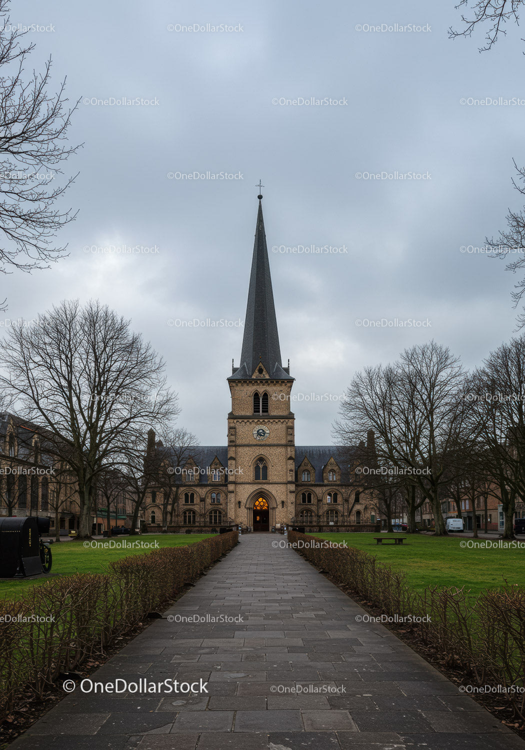Historic church tower under overcast sky in quiet park