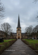 Historic church tower under overcast sky in quiet park