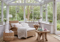 Cozy sunroom with wicker lounge and natural decor