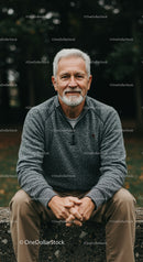 Smiling senior man sitting outdoors in casual outfit