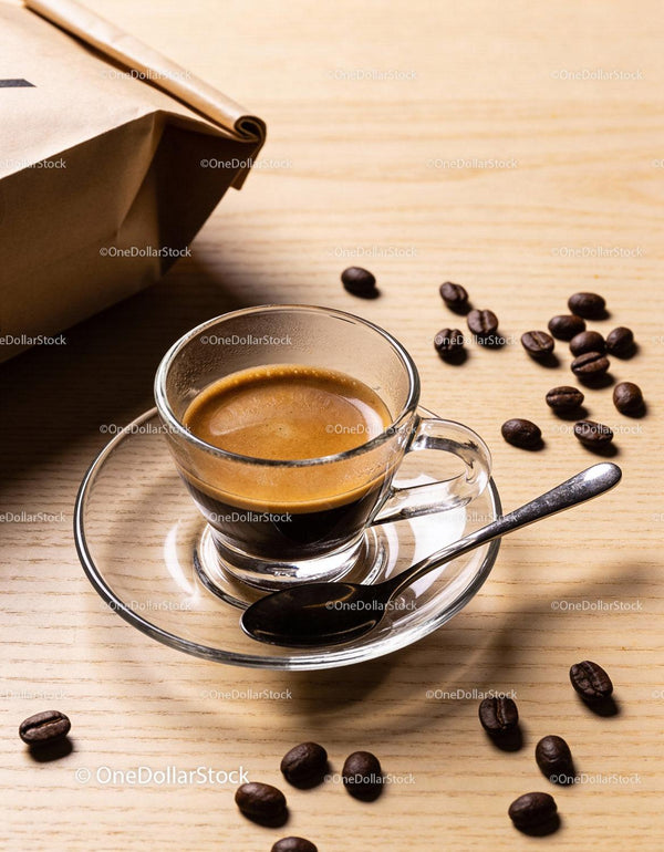 Freshly brewed espresso with coffee beans on wooden table