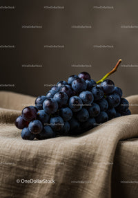 Fresh dark grapes resting on rustic linen fabric