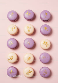 Purple and cream macarons with gold decoration on pink