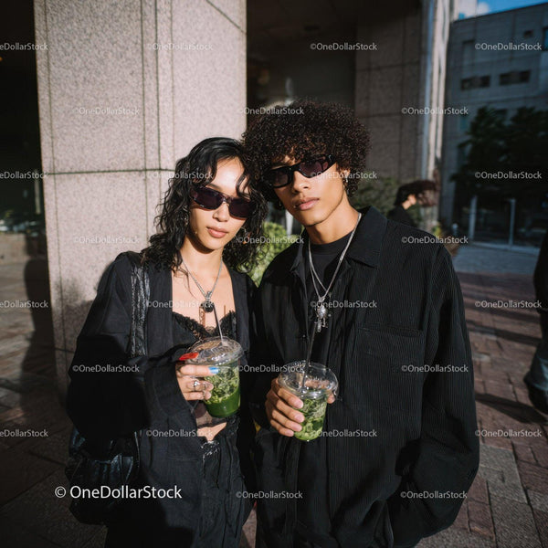 Young Stylish Couple in Black Fashion Holding Green Cocktails in City