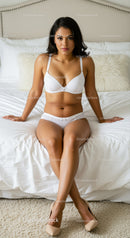 Confident woman posing in white lingerie on bed