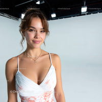 Young Woman Smiling in White Dress Against Light Blue Background