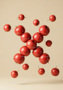 Fresh red apples suspended in beige space
