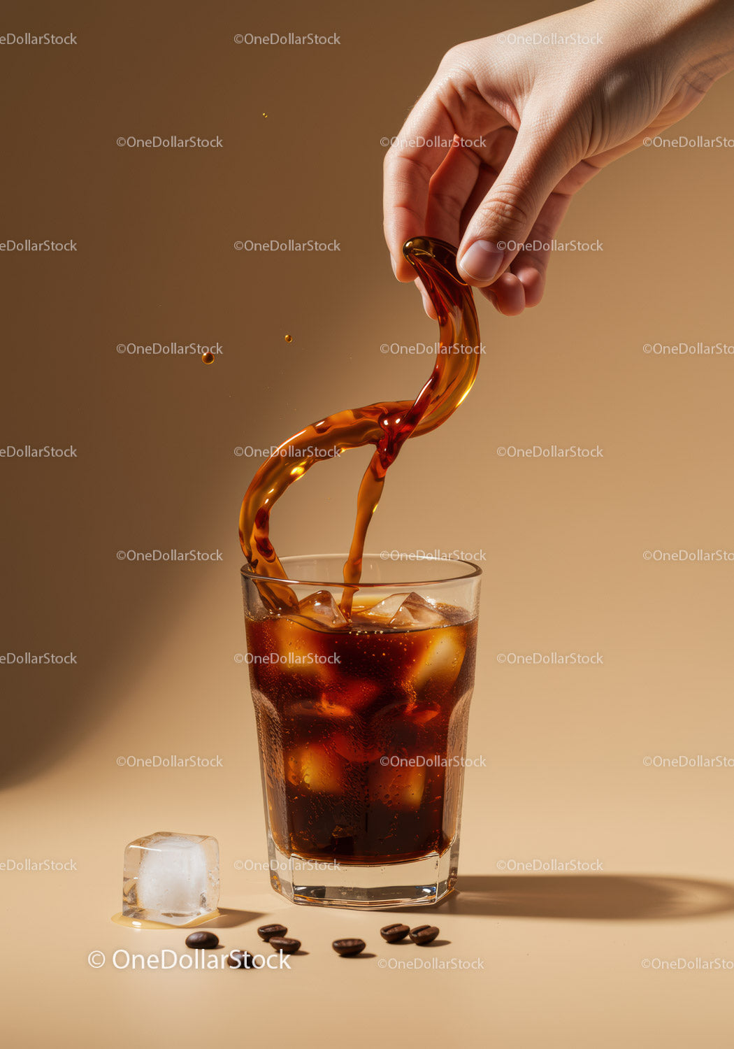 Refreshing iced coffee splash in clear glass with hand
