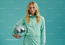 Young Woman in Mint Green Tracksuit Holding Disco Ball in Studio