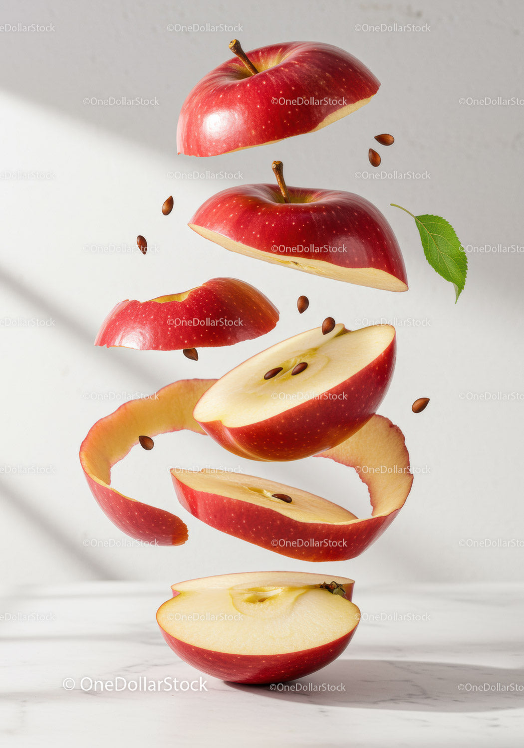 Floating red apple slices with seeds and leaf