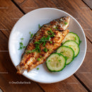 Grilled Fish with Cucumber Slices and Fresh Herbs on White Plate