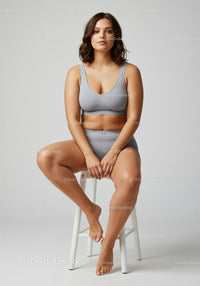 Young Woman Relaxing in Casual Sportswear Sitting on a White Chair