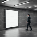 Businessman Walking Past Illuminated Blank Billboard in Modern Corridor