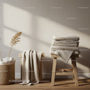 Cozy beige linens stacked on wooden stools in soft light