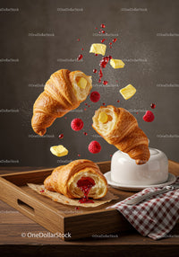 Fresh croissants with raspberry jam and melting butter