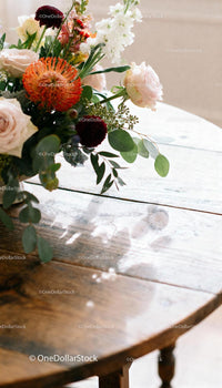 Elegant floral bouquet casting shadows on wooden table