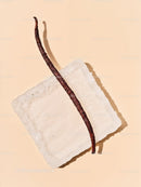 Vanilla bean pod resting on white sugar cube