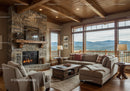Cozy living room with stone fireplace and mountain view
