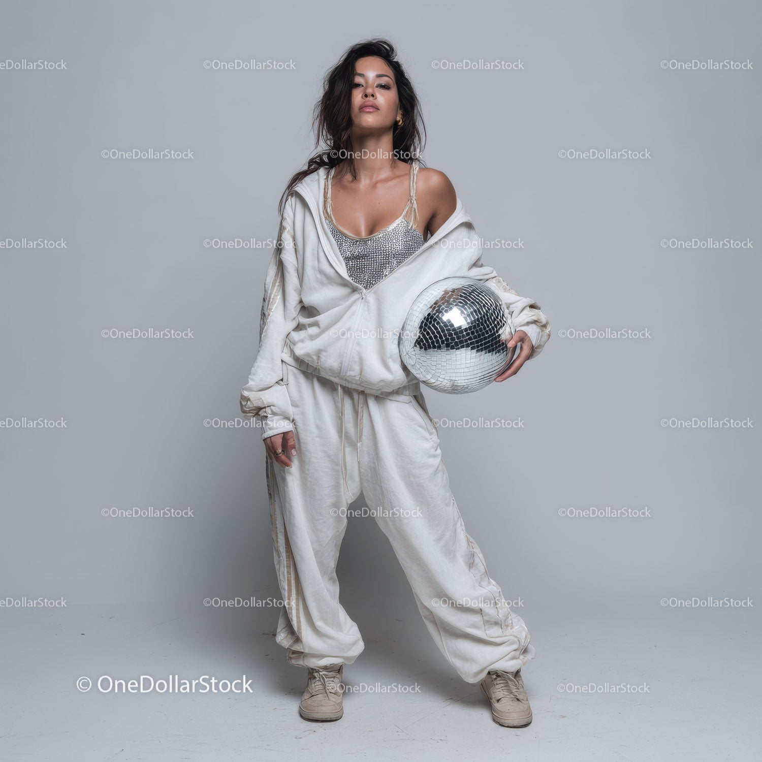 Stylish Woman in Metallic Outfit Holding Disco Ball for Modern Fashion