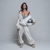 Stylish Woman in Metallic Outfit Holding Disco Ball for Modern Fashion