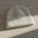 Cozy white knit beanie hat on neutral fabric