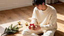 Young man holding gift box with holiday decorations