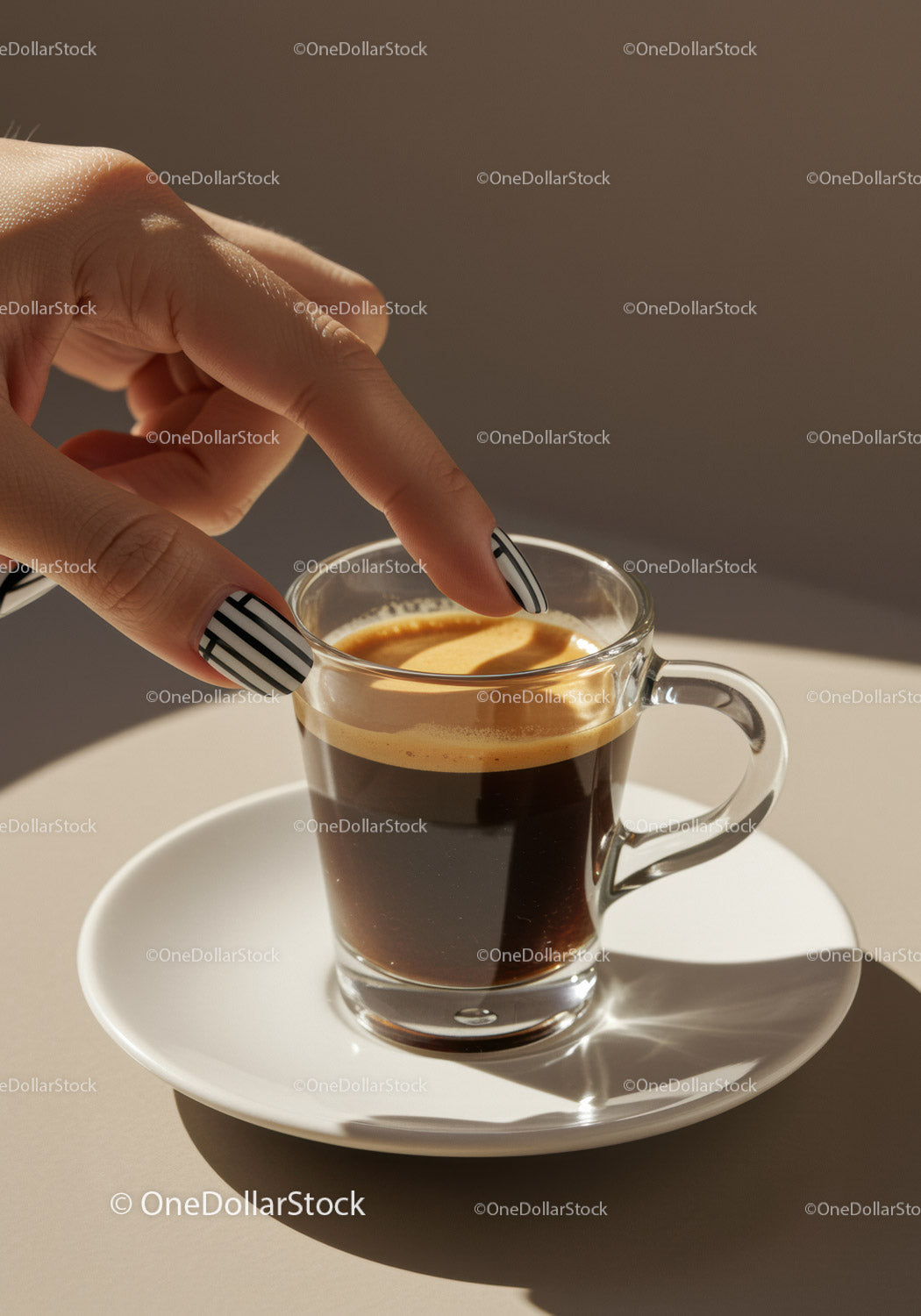 Ręka z prążkowanymi paznokciami dotykająca cremy w filiżance espresso
