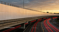 Urban Highway at Sunset with Red Light Trails and Overpass