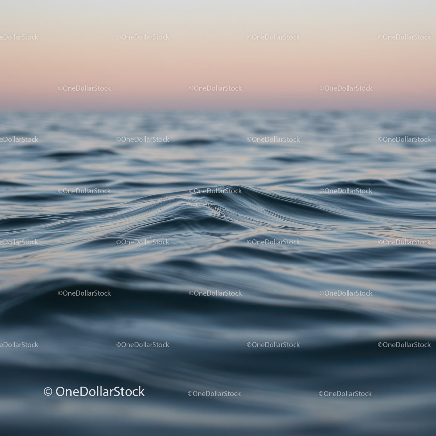 Spokojne fale oceanu o zachodzie słońca z różowym niebem