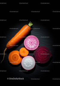 Fresh vibrant root vegetables arranged on dark surface