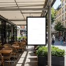 Empty outdoor cafe seating with blank street sign