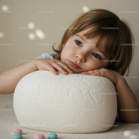 Thoughtful young child resting head on soft white cushion