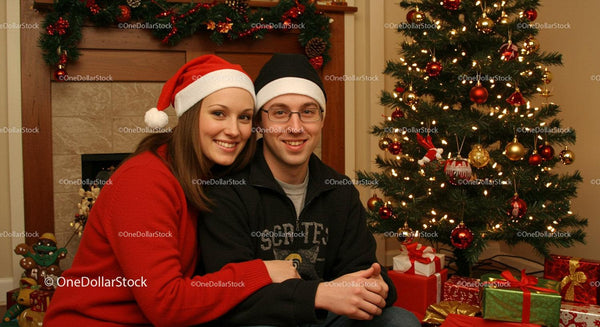 Couple Celebrating Christmas by Decorated Tree and Gifts