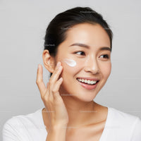 Young Asian Woman Applying Facial Moisturizer for Healthy Skin
