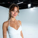 Young Woman in White Dress Smiling in Studio with Bright Lighting