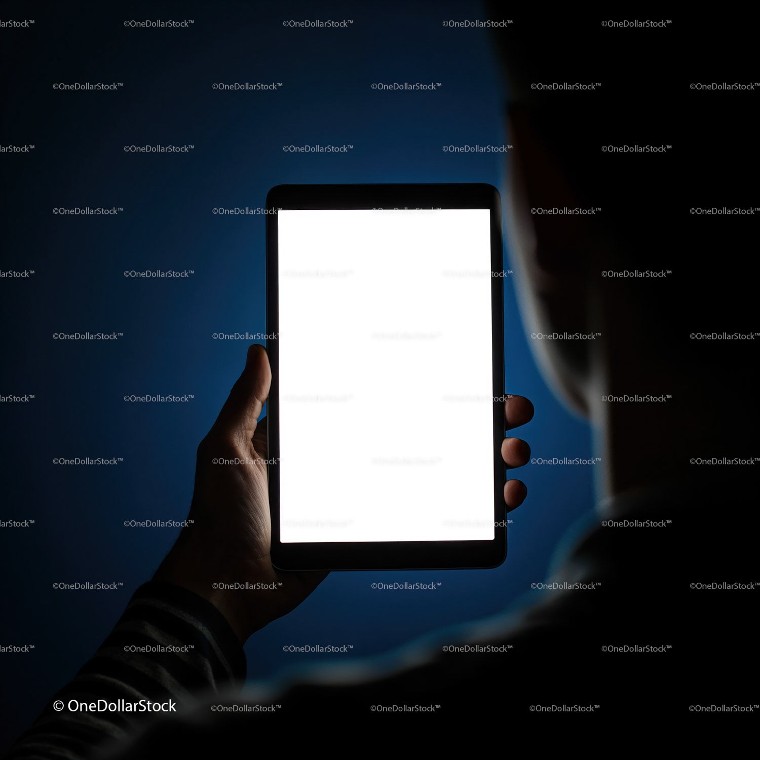 Osoba trzymająca tablet z jasnym, pustym ekranem w nocy