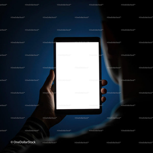 Person holding tablet with bright blank screen at night JPG Mockup Image