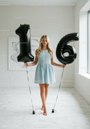 Teen girl celebrating sweet sixteen with black balloons