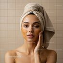 Young Woman Relaxing with Gold Facial Mask and Towel Wrapped Head