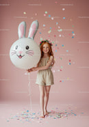 Redhead girl with floral crown holding bunny balloon