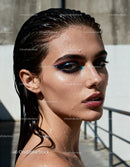Close-up portrait of a woman with wet skin and bold makeup