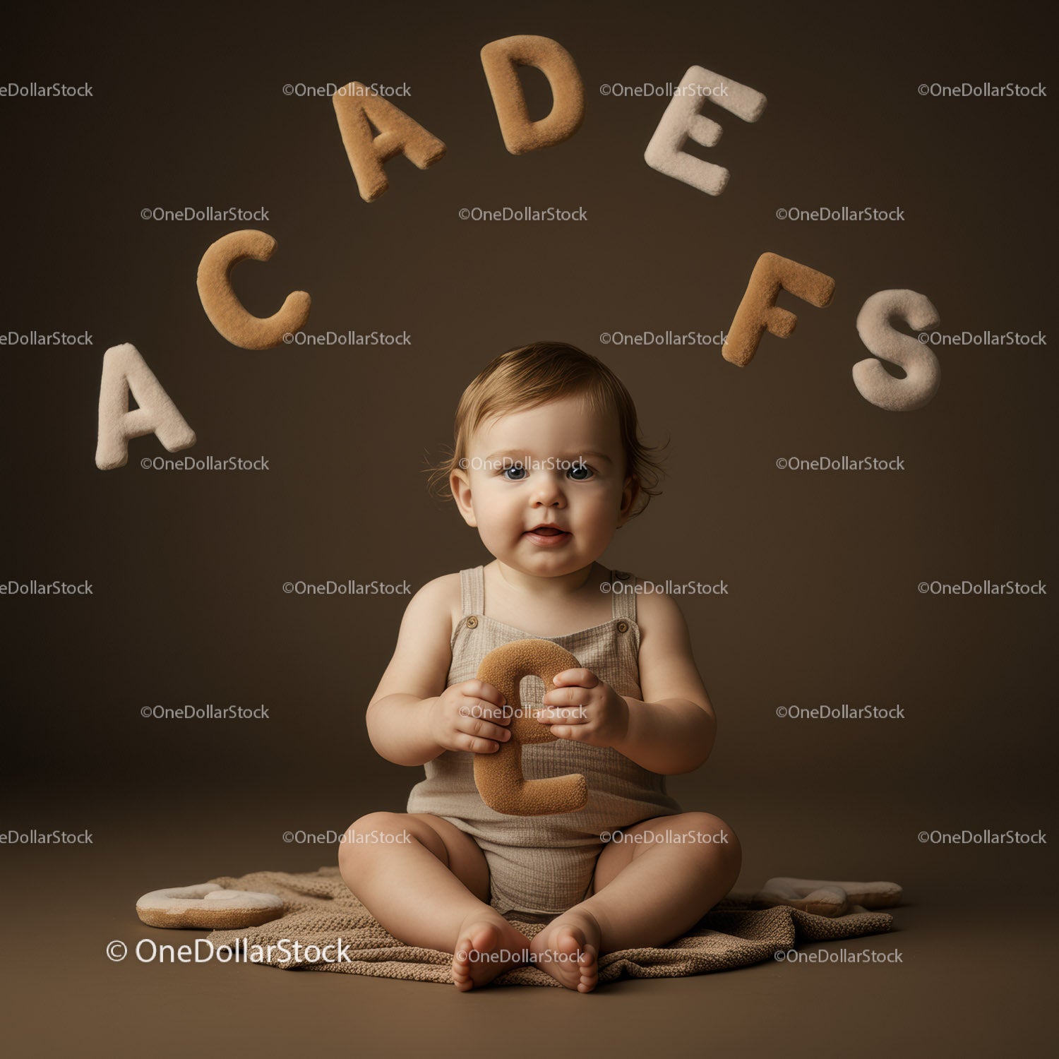 Toddler sitting with soft alphabet letters in neutral tones