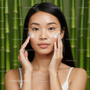 Young Woman Applying Skincare Cream with Bamboo Background